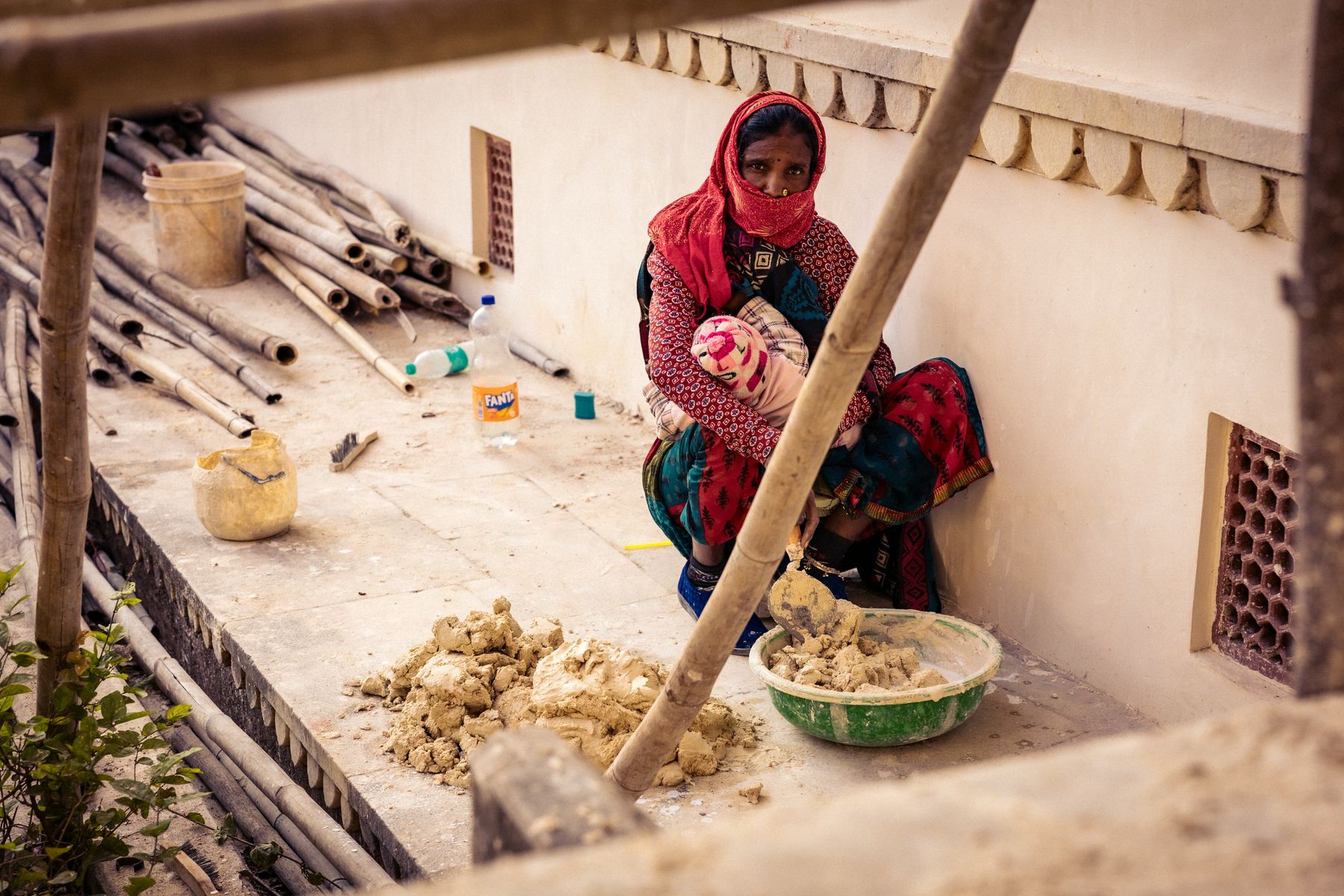 Woman Working Manual Labor While Holding Baby